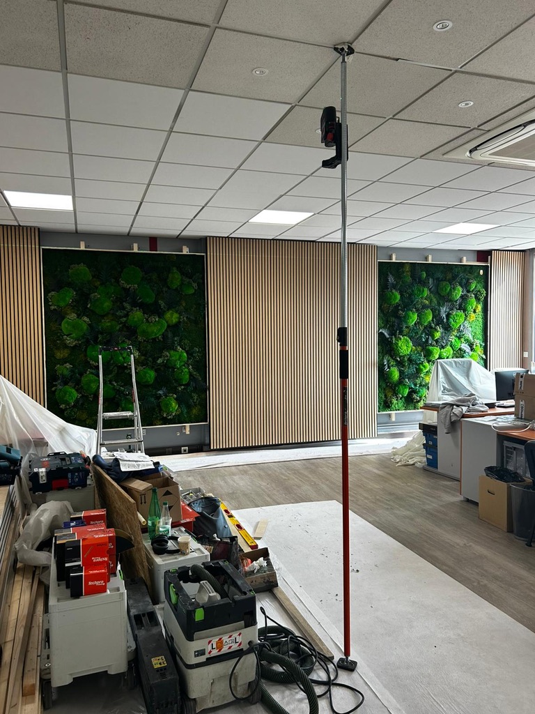 Chantier en cours — trois cadres végétaux installés dans le lattage, open space professionnel, Atelier EGEA